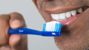 Hombre lavándose los dientes. Mito Del Autocuidado Oral